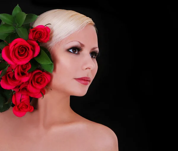 Hermosa rubia joven con rosas rojas sobre fondo negro, retrato de moda — Foto de Stock