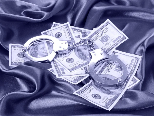 Money and handcuffs on silk fabric, dollars bills — Stock Photo, Image