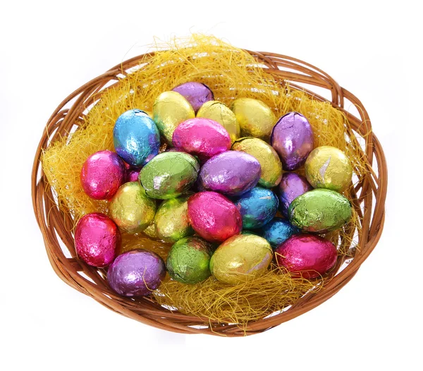 Coloridos huevos de Pascua de chocolate en cesta aislada sobre fondo blanco — Foto de Stock