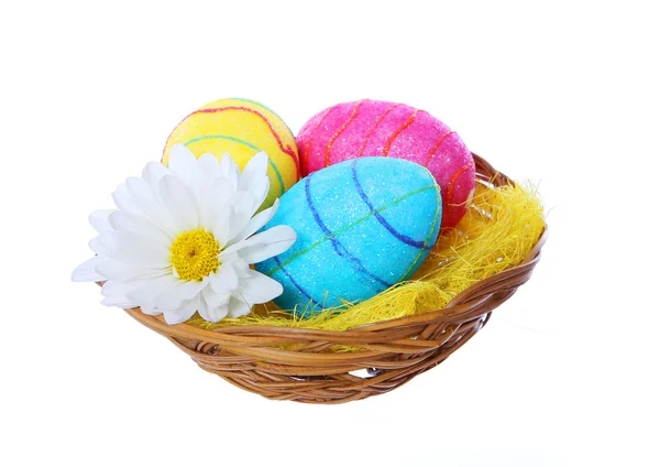 Huevos de Pascua en cesta con flor de manzanilla aislada sobre fondo blanco — Foto de Stock