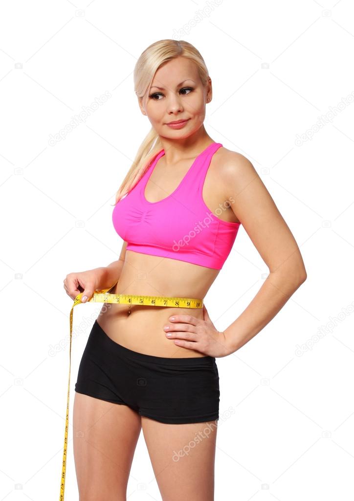 fitness girl with measure tape. beautiful blonde young woman measuring her waist isolated on white background