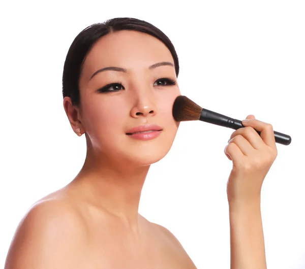 Woman with makeup brush. beautiful Asian brunette applying blush on her cheek, isolated on white — Stock Photo, Image