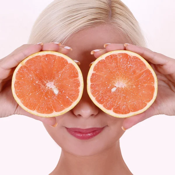 Mädchen mit orangefarbenen Früchten auf weißem Hintergrund, lächelnde blonde junge Frau. Gesundheitsversorgung — Stockfoto