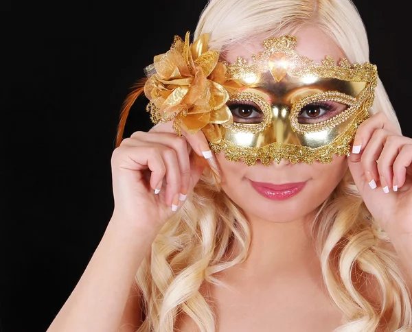 Menina loira com máscara de carnaval de ouro sobre fundo preto. Disfarce. Halloween. — Fotografia de Stock