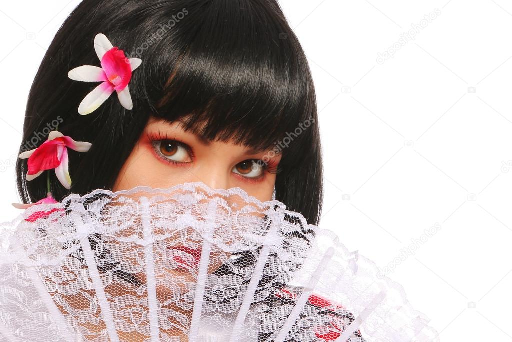 Brunette with lace fan and beautiful flowers in her black bob hair over white background. geisha