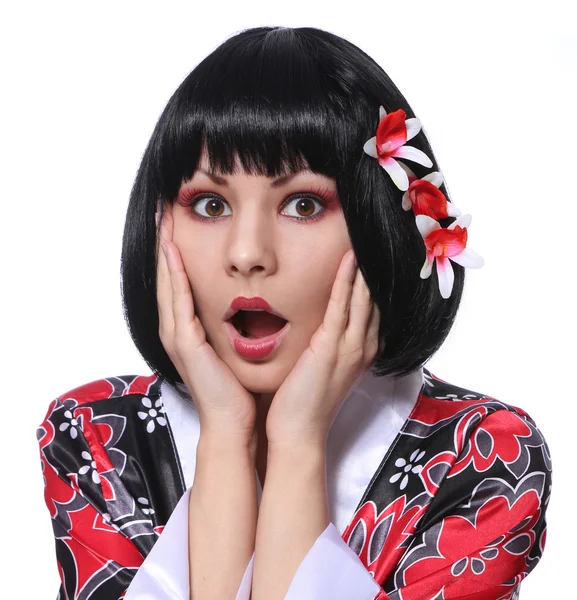Geisha sorprendida, retrato de mujer joven en kimono y hermosas flores en su pelo corto negro aislado en blanco, maquillaje de moda. Halloween — Foto de Stock