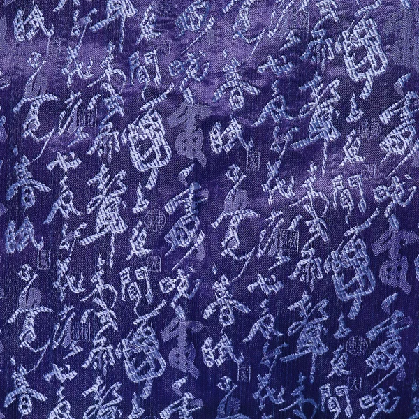 Les hiéroglyphes chinois sont brodés sur un matériau bleu. Contexte. Matières textiles — Photo