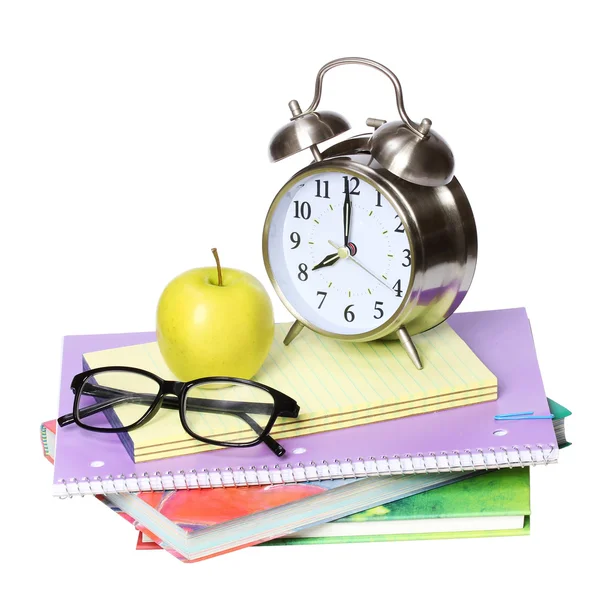 De vuelta al concepto escolar. Una manzana, reloj despertador y vasos sobre un montón de libros aislados sobre fondo blanco —  Fotos de Stock