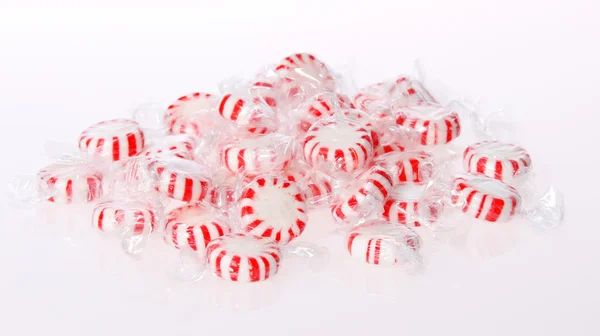 Peppermint candy pile on white background. Red striped peppermint Christmas candy, macro. — Stock Photo, Image