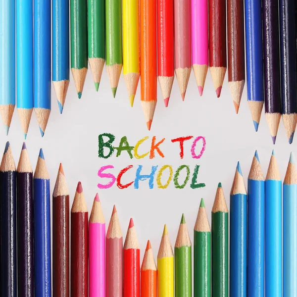 Back to school concept. Colorful pencils arranged as heart. The words 'Back to School' written in pencil in the heart shape — Stock Photo, Image