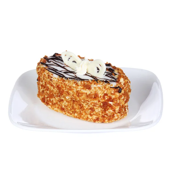 Delicioso pastel de miel con chocolate en la parte superior en un plato, aislado en blanco — Foto de Stock