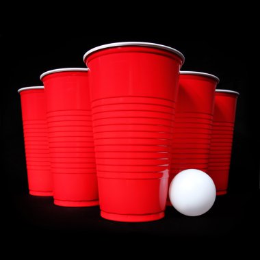 bira pong. kırmızı plastik bardak ve ping pong topu siyah arka plan üzerinde