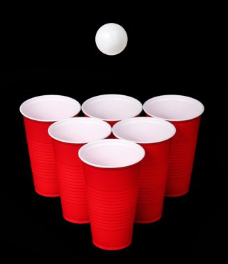 bira pong. kırmızı plastik bardak ve ping pong topu siyah arka plan üzerinde