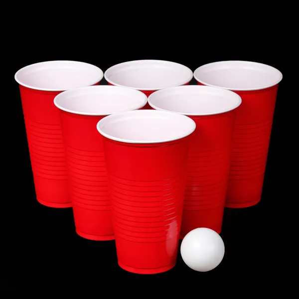 Cerveja-pongue. Copos de plástico vermelho e ping pong bola sobre fundo preto — Fotografia de Stock