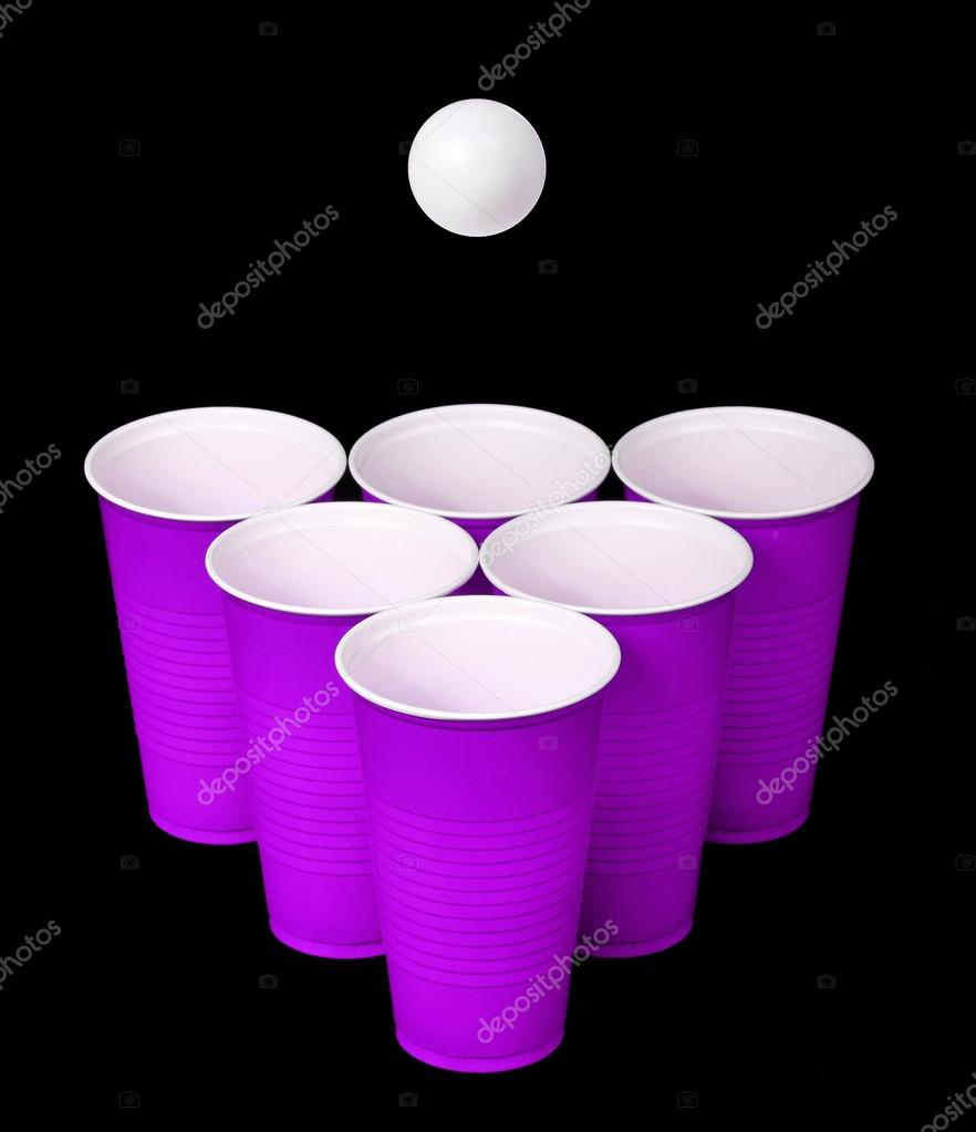 Beer pong. Purple plastic cups and ping pong ball over black