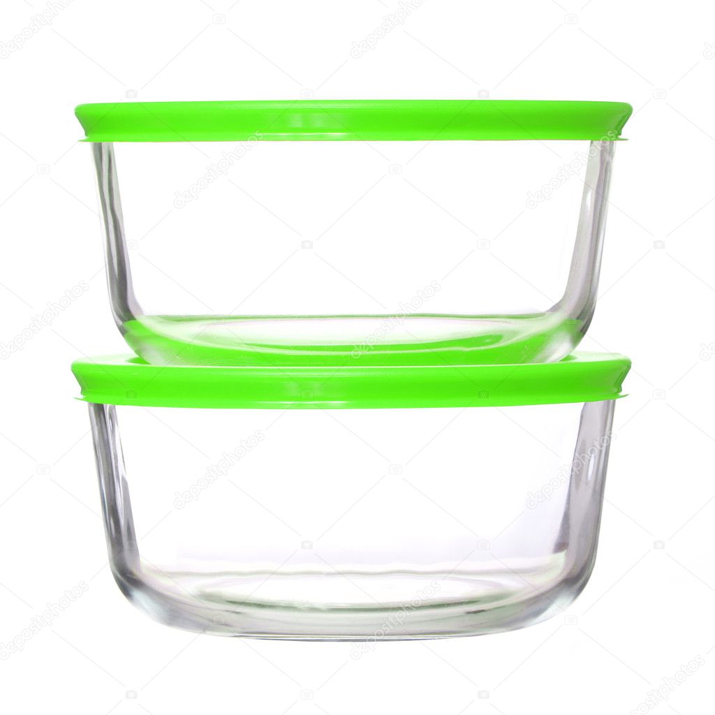 Glass food containers with green plastic lids isolated on white background