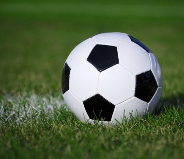 Soccer ball on the field with yard line. Football on green grass