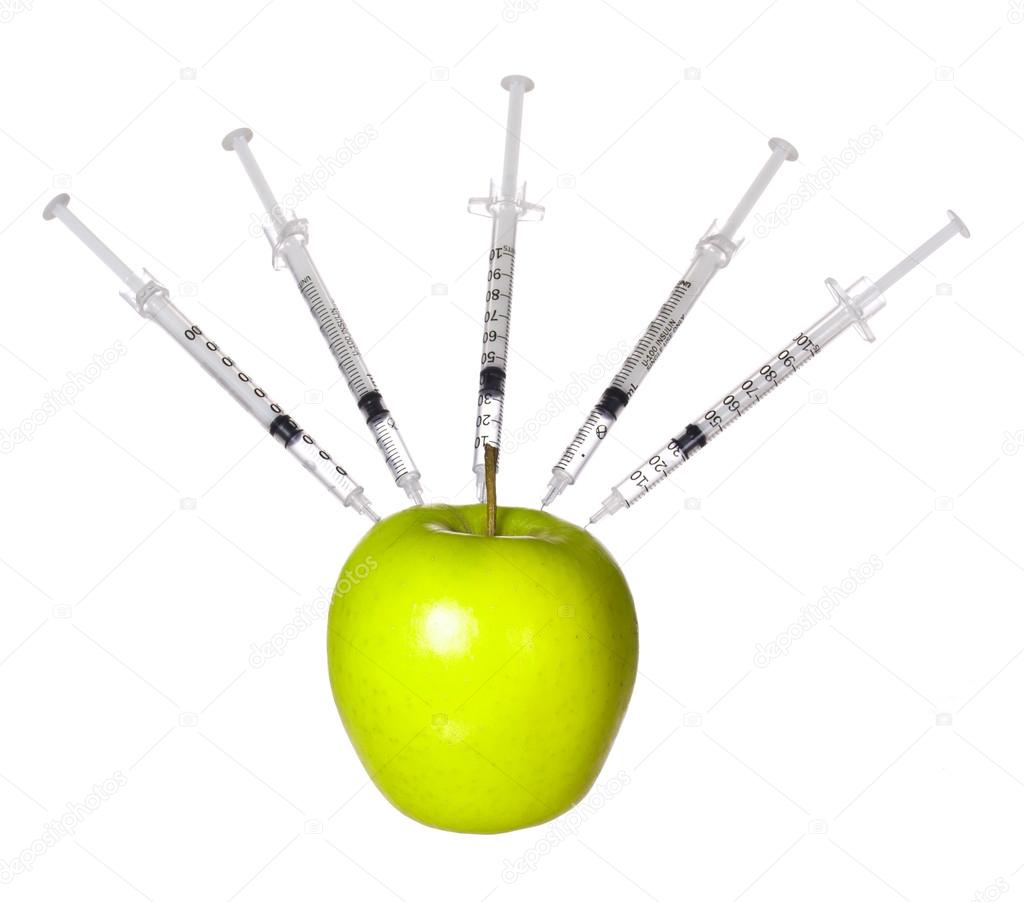 GMO food concept. Genetically modified green apple and syringes isolated on white background. Genetic injections