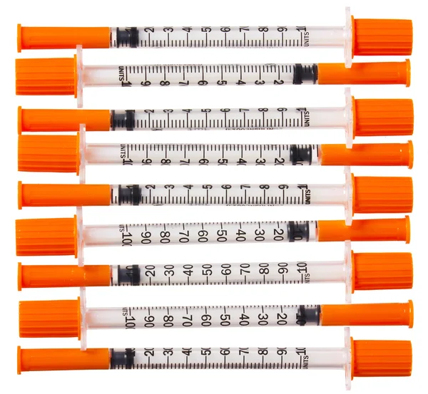 Seringues avec bouchons orange isolés sur blanc. Injections — Photo