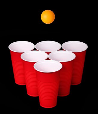 bira pong. kırmızı plastik bardak ve siyah arka plan üzerinde turuncu Masa Tenisi topu. portre