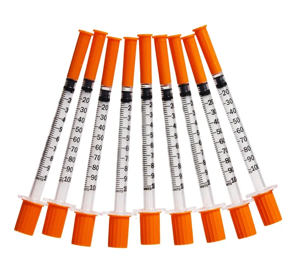 Spuiten met oranje doppen geïsoleerd op wit. injecties — Stockfoto