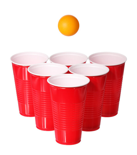 Beer pong. Red plastic cups and orange ping-pong ball isolated on white background. Closeup