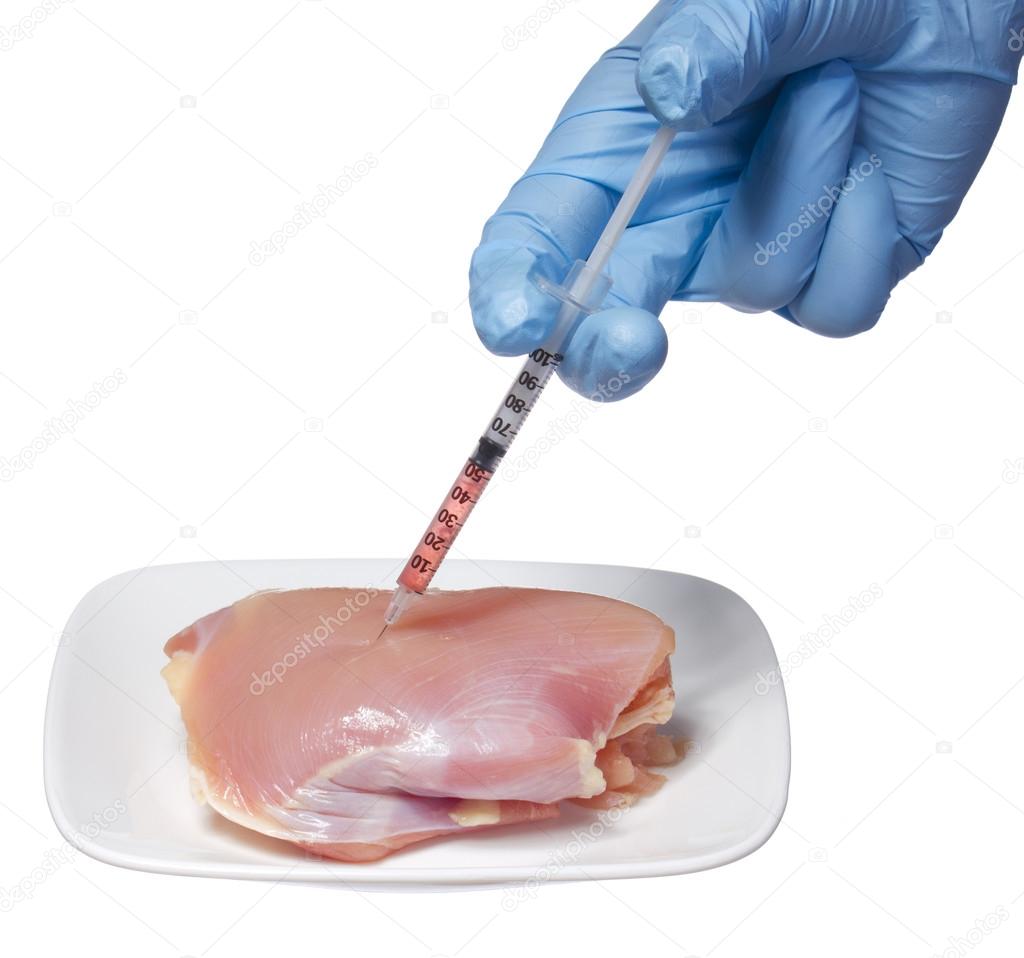 injection into raw chicken meat on square plate isolated on