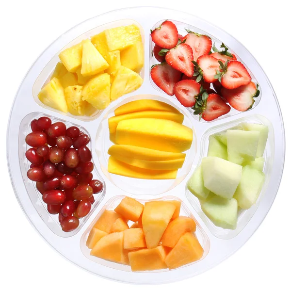 Frutta fresca in recipiente rotondo di plastica isolato su bianco. Diversi tipi di frutta a fette: mango, melone, fragole, uva, ananas. Vita sana . Immagini Stock Royalty Free