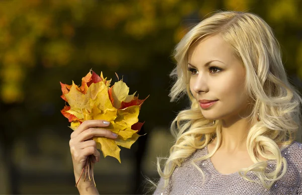 Осенняя девушка моды. Блондинка красивая молодая женщина с желтыми кленовыми листьями в руке. Снаружи. Падение — стоковое фото