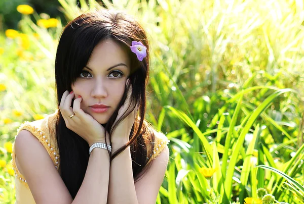 Brunette meisje op groen gras in zomer park. Portret van jonge mooie vrouw — Stockfoto