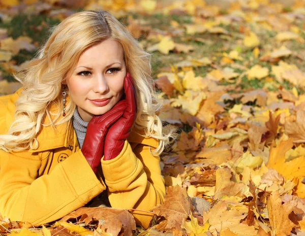Szőke lány juhar őszi parkban levelek. szép divat — Stock Fotó