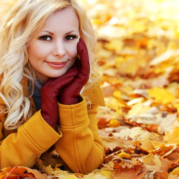 Φύλλα ξανθού κοριτσιού στο φθινόπωρο πάρκο με το σφένδαμνο. όμορφη μόδας — Φωτογραφία Αρχείου