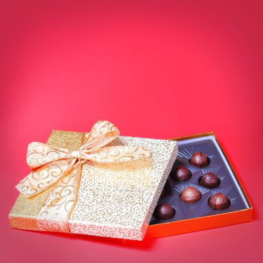 domalan kırmızı zemin üzerine altın şeker kutusu. Noel hediyesi