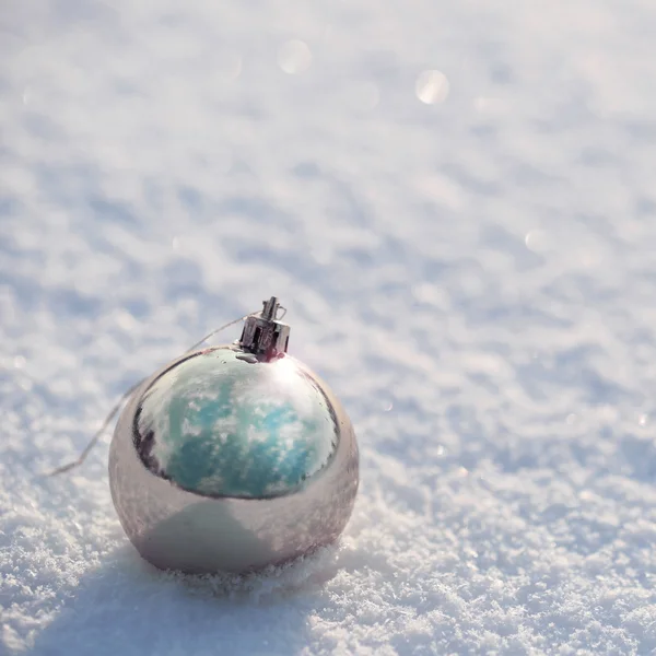 Ezüst karácsonyi golyó a hó. kívül. téli napsütéses napon. — Stock Fotó