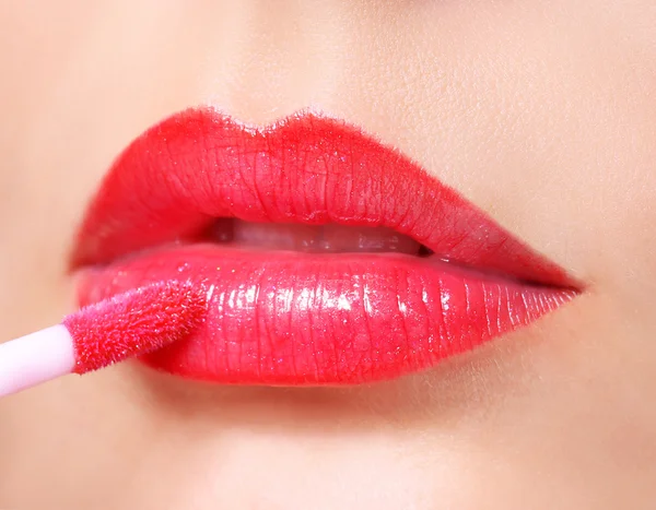 Rode lippenstift. lipgloss op sexy lippen en borstel. make-up. — Stockfoto