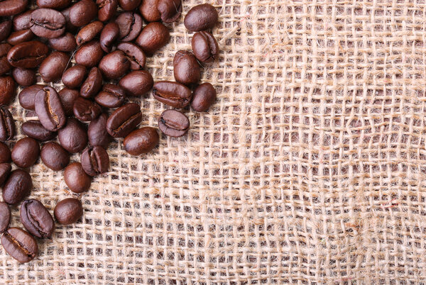 Coffee Beans on Burlap Background.
