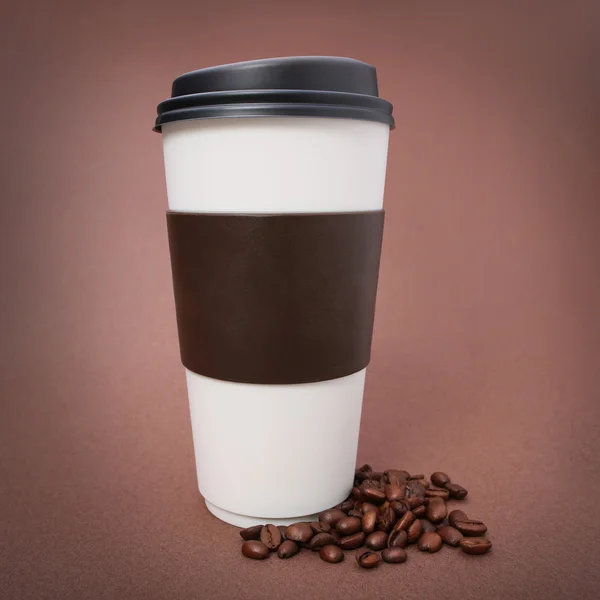 Papier tasse de café avec grains de café sur fond brun. À emporter — Photo