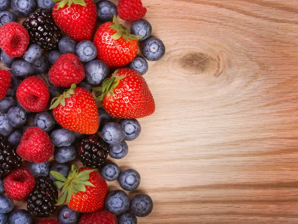 Bayas sobre fondo de madera. Fresas, arándanos, frambuesas y moras . —  Fotos de Stock