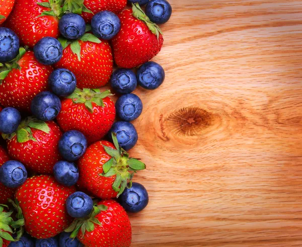 Bacche su sfondo di legno. Fragole e Mirtilli — Foto Stock