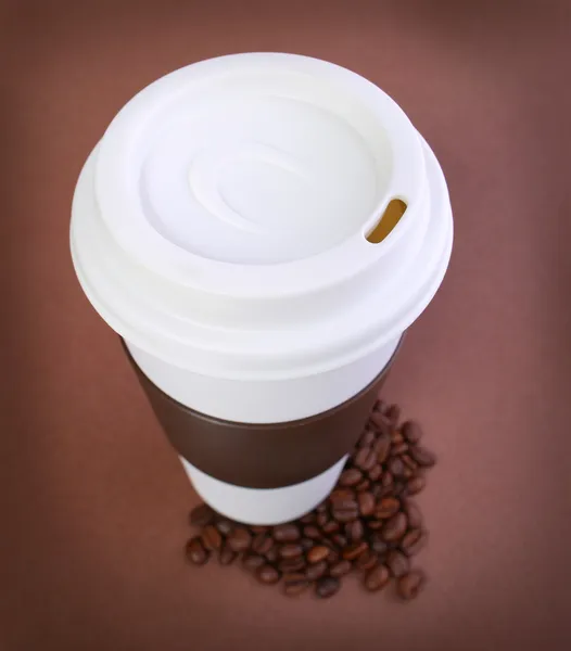 Tazza di caffè con chicchi di caffè su sfondo marrone. Takeaway o Di — Foto Stock
