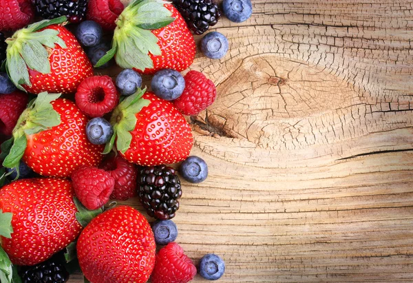 Bessen op houten achtergrond. aardbeien, bosbessen — Stockfoto