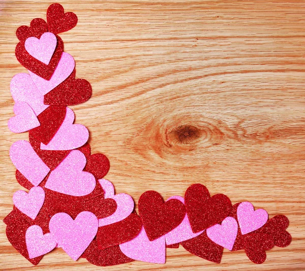 De dag van Valentijnskaarten achtergrond. glitter rood en roze hartjes op houten — Stockfoto
