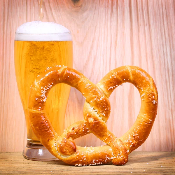 Cerveza con pretzel alemán sobre fondo de madera — Foto de Stock