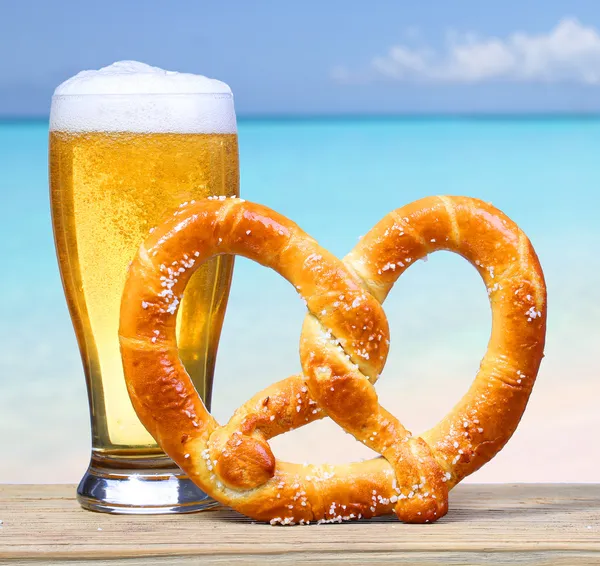 Copo de cerveja com Pretzel alemão sobre vista para o mar. Férias — Fotografia de Stock