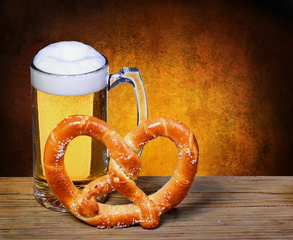 Taza de cerveza con pretzel alemán en mesa de madera. aislado en blanco —  Fotos de Stock