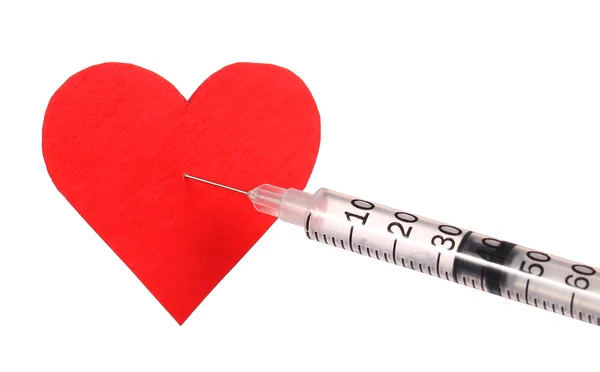 Rotes Herz in der Nähe einer Spritze mit Drogen. — Stockfoto