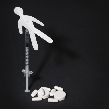 Drug Addiction Concept. Paper man with syringe and pills clipart