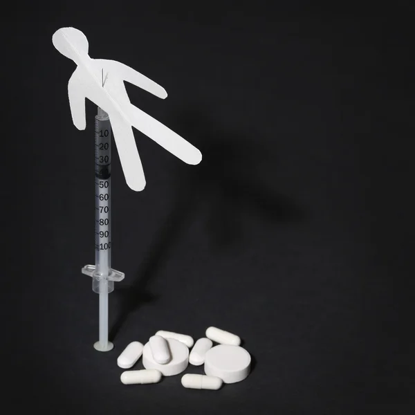 Drug verslaving concept. papier man met spuit en pillen — Stockfoto