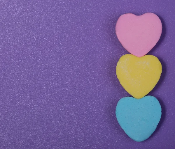 Corações coloridos. Três doçura querida sobre fundo roxo — Fotografia de Stock