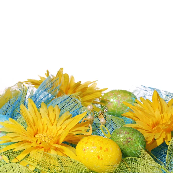 Margherite gialle con uova di Pasqua su sfondo bianco — Foto Stock